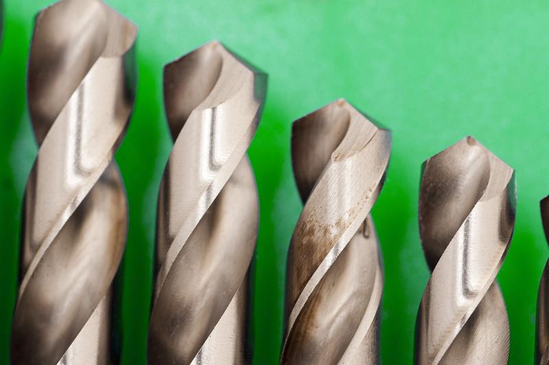 Free Stock Photo: Close up of the tips of a set of metal steel spiral woodworking drill bits in descending size on a green background with copyspace