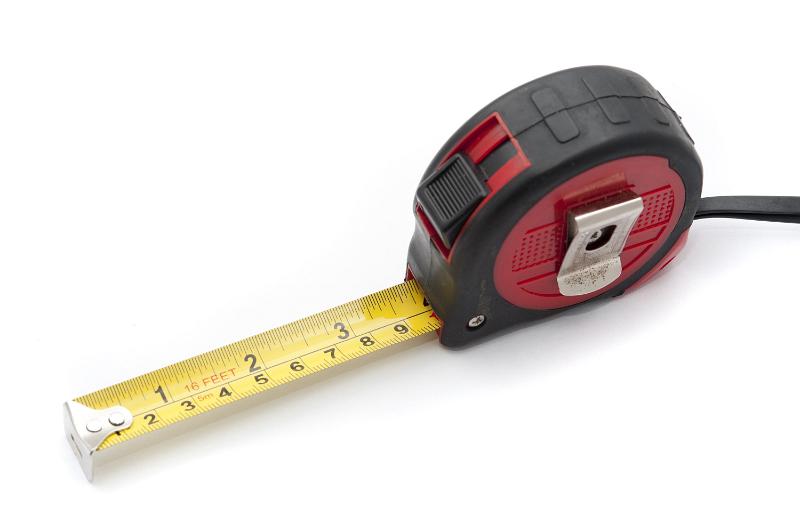 Free Stock Photo: Builders retractable tape measure with scales in both inches and centimeters on white ina DIY and renovation concept