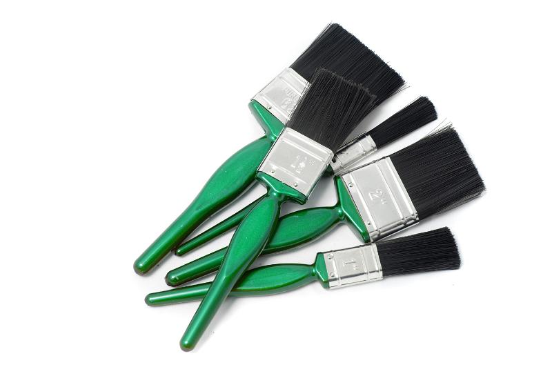 Free Stock Photo: Set of new paint brushes with colorful green handles for painting a building interior lying on a white background with copyspace in a DIY and renovation concept