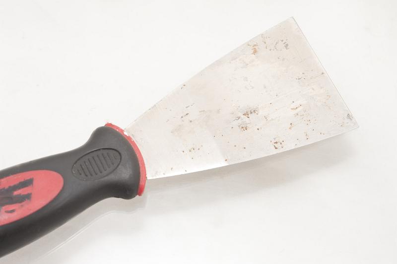 Free Stock Photo: Metal scraper for scraping off old walls, wallpaper and plaster prior to repainting or wallpapering in a DIY and interior decorating concept