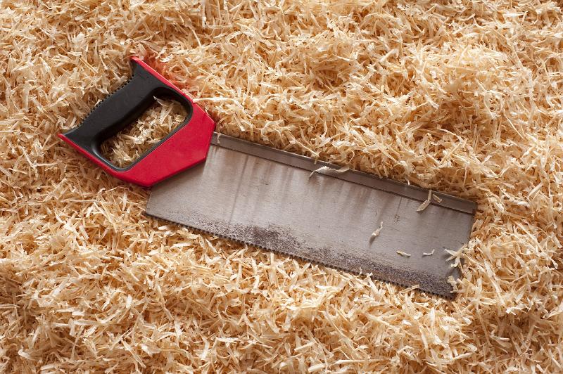 Free Stock Photo: Saw with red handle laying on wood shavings