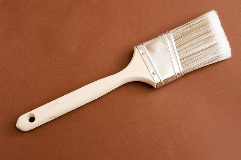 Free Stock Photo: Wooden paintbrush for painting walls lying diagonally across a brown background with copyspace, viewed from above in a DIY concept