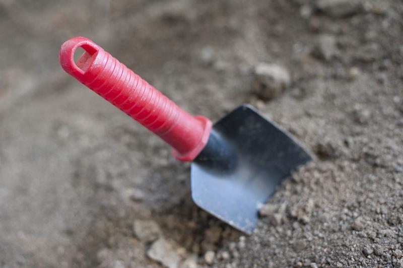 Free Stock Photo: Small garden trowel with a red plastic handle in dry soil ready for digging over the earth