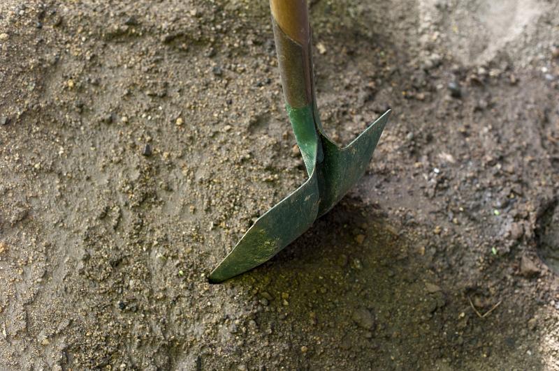 Free Stock Photo: Green metal garden spade or shovel standing upright in soil viewed from above with copyspace