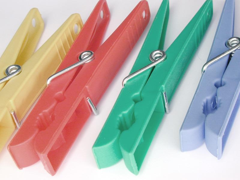 Free Stock Photo: Four colorful plastic clothes pegs on a white background conceptual of housework, cleanliness and laundry
