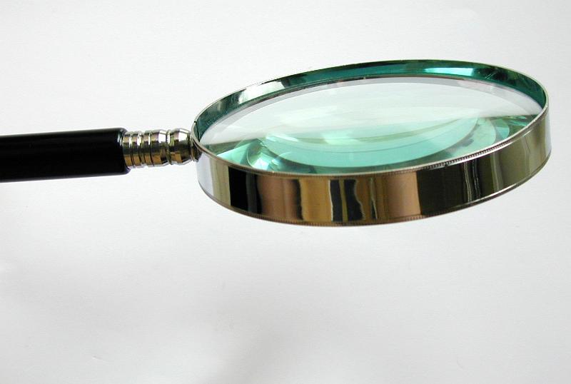 Free Stock Photo: Magnifier with thick lens, metallic frame and black plastic handle, tool used in research, investigations and detailed observations for increased view, close-up with copy space on gray