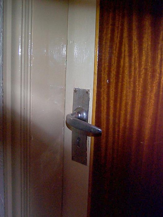 Free Stock Photo: Detail of Silver Colored Door Handle on Closed Door with Large Curtained Window, Partially Obscured by Shadow