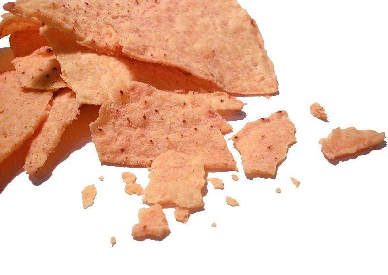 Free Stock Photo: Closeup of a crushed potato crisp with seasoning scattered on a white background