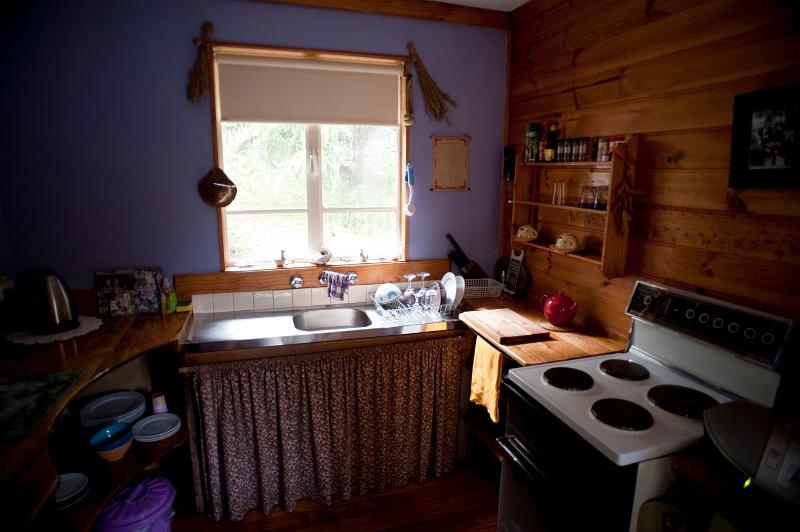 Free Stock Photo: Interior of a cottage kitchen with rustic wooden countertops and curtained units