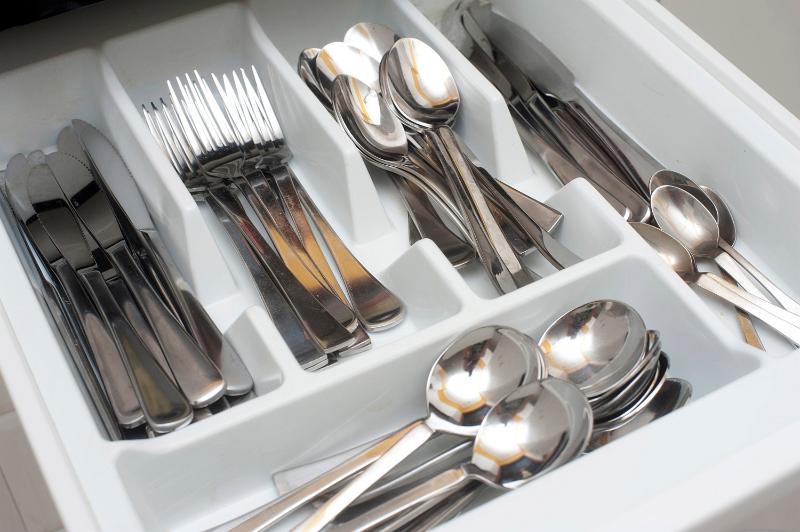 Free Stock Photo: Open cutlery drawer with inside dividers filled with silver stainless steel knives, forks, spoons and teaspoons for eating