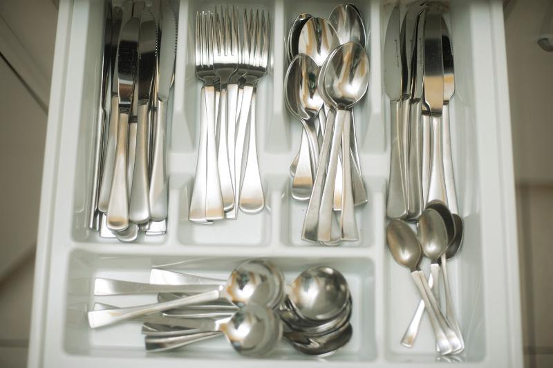 Free Stock Photo: Open cutlery drawer with an inside divided tray for neat storage of silver metal knives, forks, spoons and teaspoons