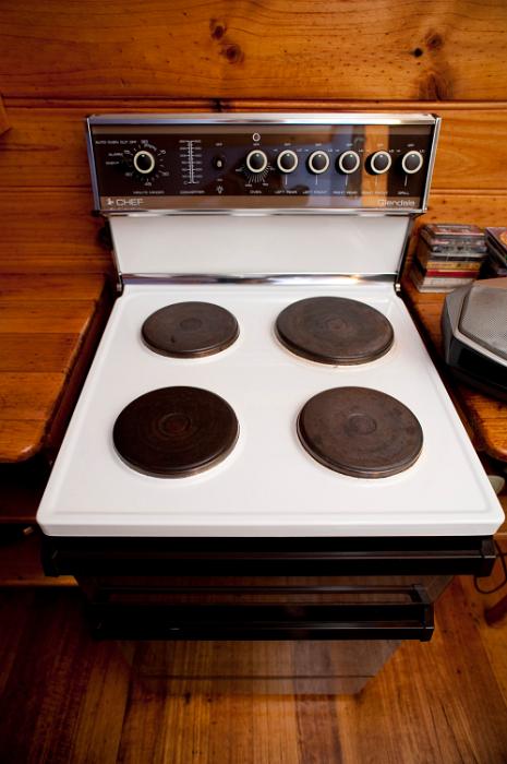 Free Stock Photo: Modern domestic freestanding stove with four solid hot plates in a wooden kitchen for cooking food and household meals