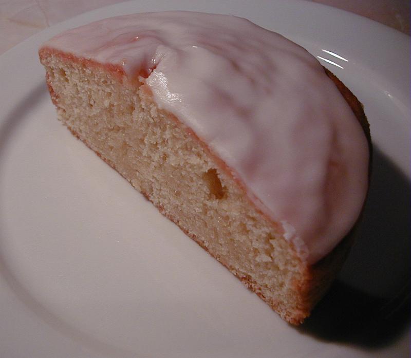 Free Stock Photo: High angle closeup of a halved freshly baked cake with icing served on a white plate as a delicious dessert or snack