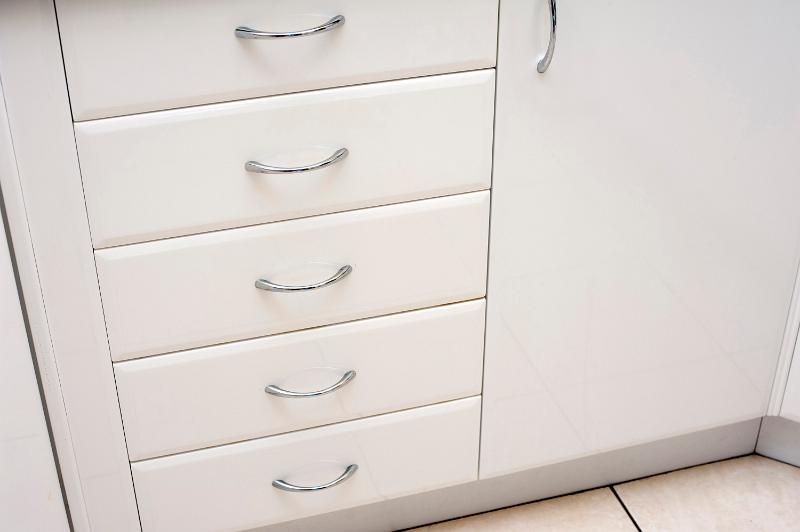 Free Stock Photo: White kitchen cabinet with a row of closed drawers and a cupboard door