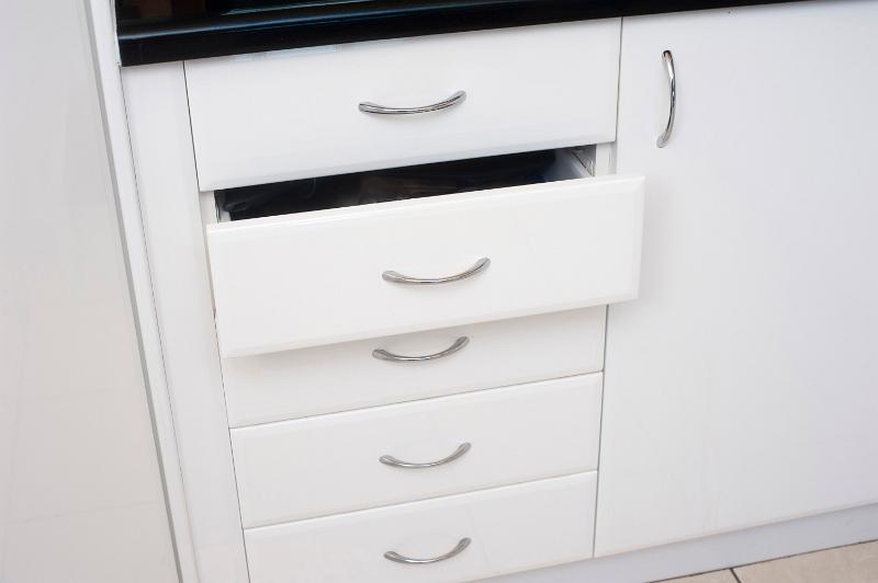 Free Stock Photo: Set of white kitchen drawers in a built in cabinet unit with one drawer slightly open