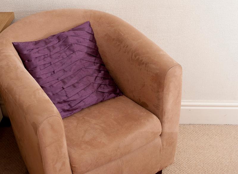 Free Stock Photo: Comfortable empty upholstered brown curved armchair with a cushion, close up view