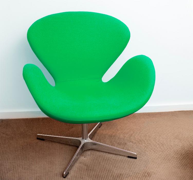 Free Stock Photo: Contemporary green modular armchair with a steel base on a brown carpet in front of a white wall in an interior decor concept
