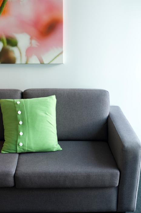 Free Stock Photo: Green cushion on a vacant modern upholstered grey couch, close up view