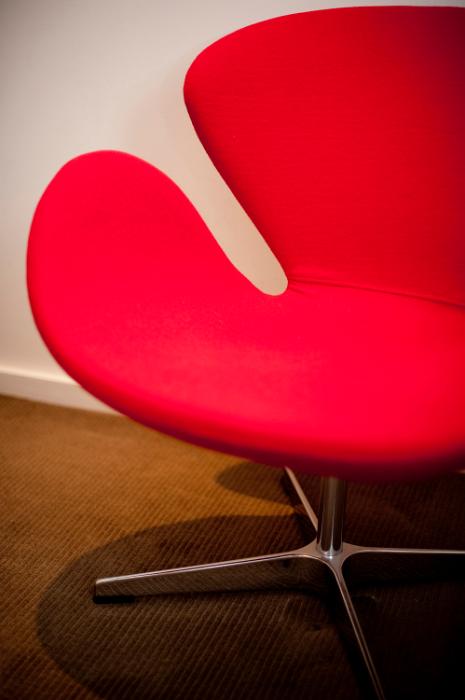 Free Stock Photo: Modern red designer chair with a circular cut out modular design on a hardwood floor, only half visible