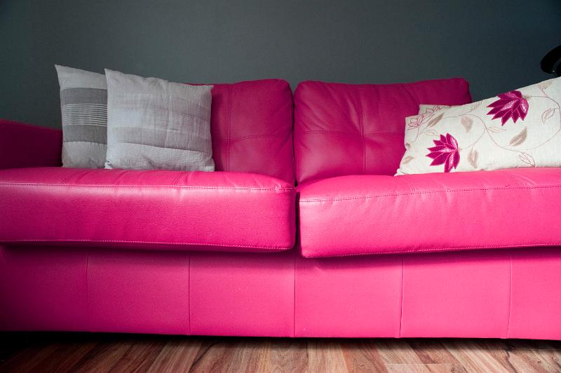 Free Stock Photo: Low angle floor level view of a colorful bright pink lounge suite with stylish floral cushions