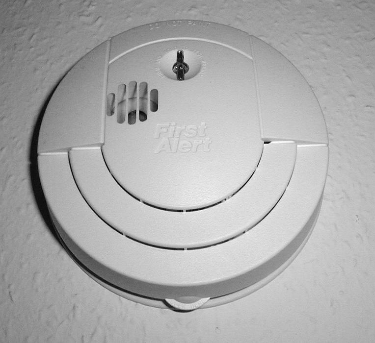Free Stock Photo: Modern white plastic circular smoke detector mounted on a wall or ceiling to act as an early warning in the event of fire