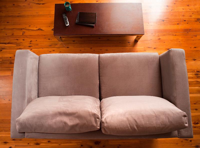 Free Stock Photo: Overhead view of a deserted lounge interior with a comfortable upholstered brown settee and coffee table on a hardwood floor