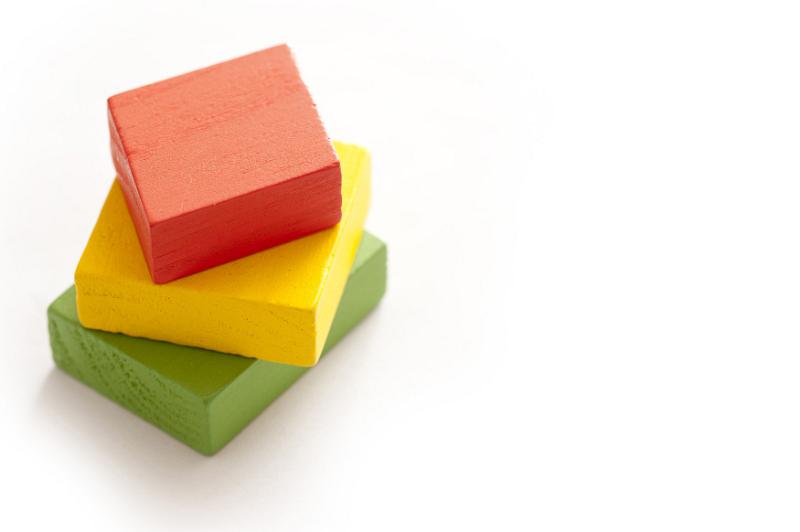 Free Stock Photo: Single stack of red, yellow and green painted blocks for babies over white background with copy space