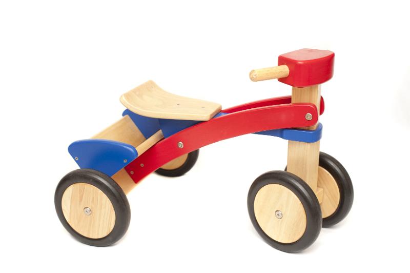 Free Stock Photo: Simple kids wooden toy tricycle with colorful red and blue painted accents isolated on white
