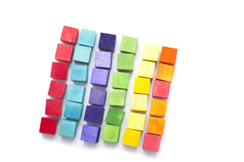 Free Stock Photo: Colorful still life of wooden toy building blocks or cubes arranged in a square in neat color differentiated rows on a white background