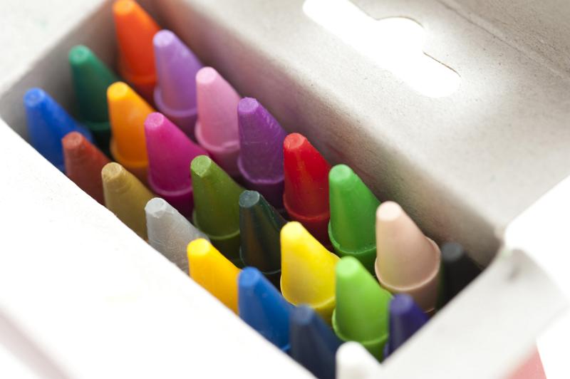 Free Stock Photo: Box full of colored wax crayons viewed from above with the lid open looking down on the tips in the colors of the spectrum in an art and creativity concept