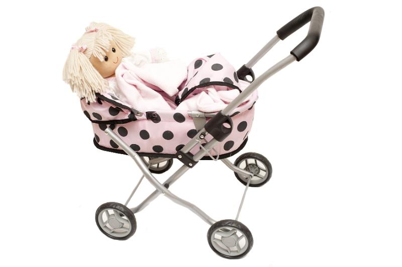 Free Stock Photo: Little blond doll in a kids pink toy pram or stroller with black polka dots isolated on white