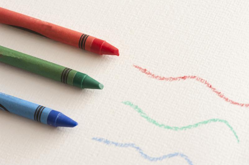 Free Stock Photo: Green, red and blue colored wax crayons with squiggly hand drawn lines over textured paper viewed high angle