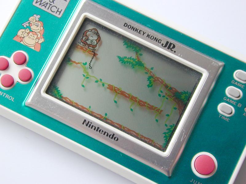 Free Stock Photo: Kids video game and watch illuminated screen with a monkey in a tree and colorful plastic dials