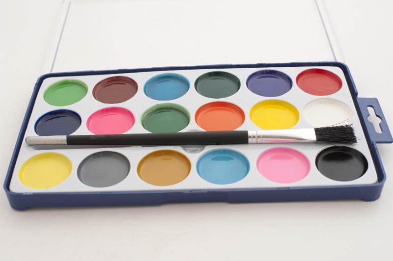 Free Stock Photo: New open watercolor paint box and paint brush for kids with colorful paints in rows in circular pots