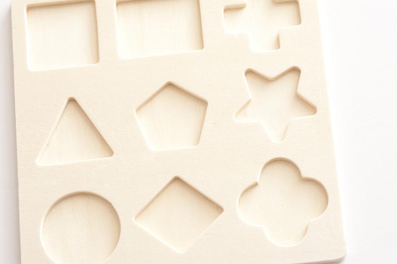Free Stock Photo: Wooden board puzzle with nine different basic cut out shapes into which to fit matching blocks for educating children