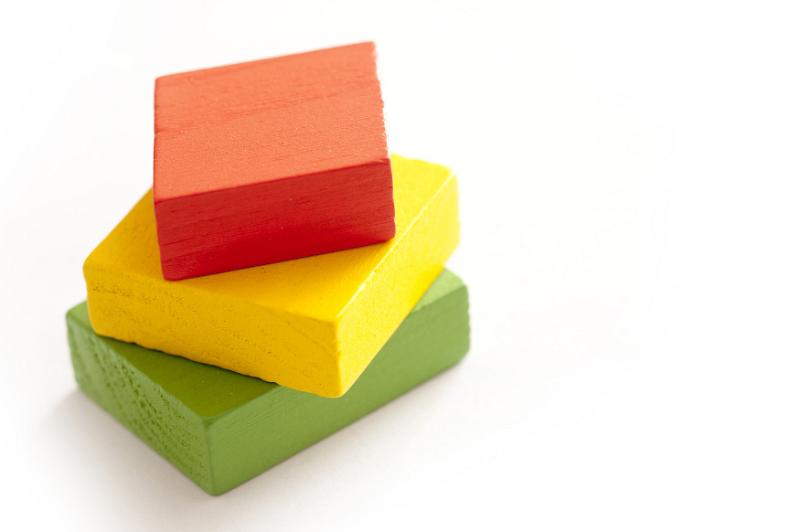 Free Stock Photo: Red, yellow and green toy blocks stacked on white background with copy space