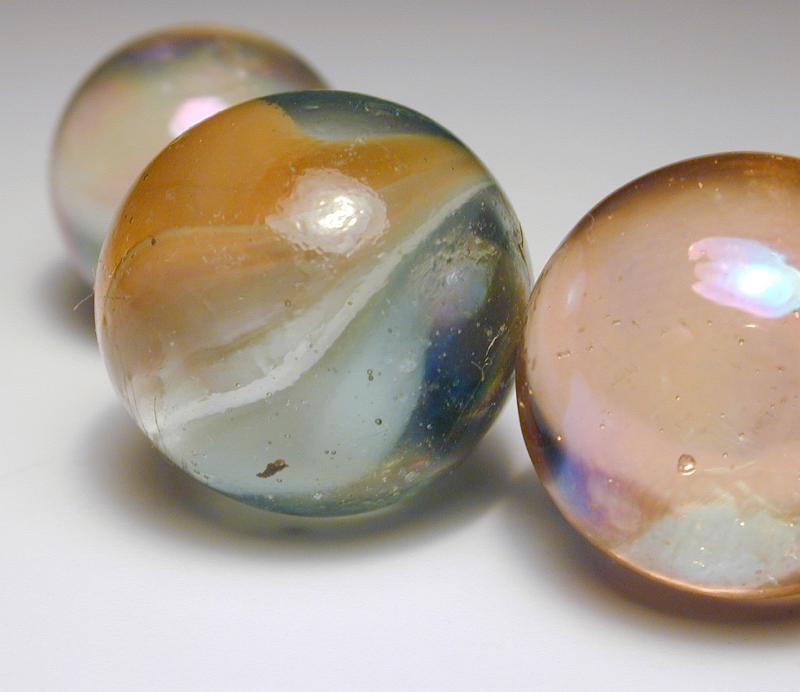 Free Stock Photo: Close Up of Three Glass Marbles in Different Sizes on White Studio Background with Foreground Copy Space