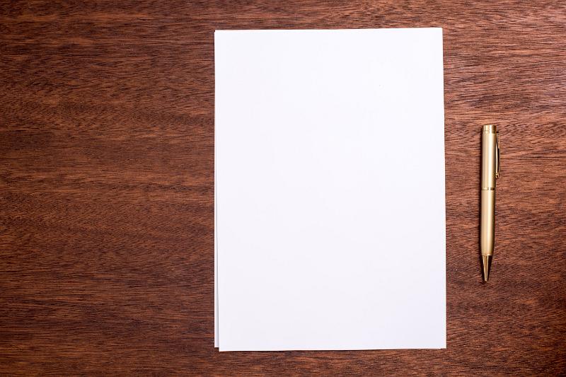 Free Stock Photo: Blank page of white paper and pen on a wooden table or desk viewed from above with copy space for text
