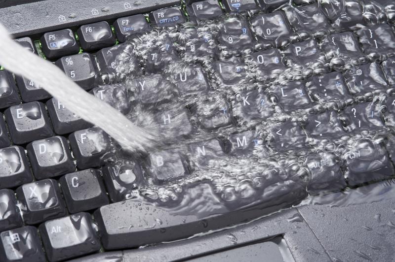 Free Stock Photo: Computer data cleaning concept with fresh water flooding over a black keyboard being poured from the side in a full frame view