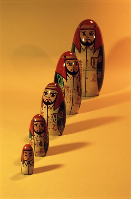 Free Stock Photo: Set of Russian Matryoshka or Babushka dolls in a receding line arranged according to size on an orange background with copy space