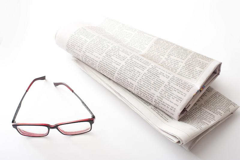 Free Stock Photo: Reading newspapers concept with a pair of glasses and two folded fresh newspapers on white table surface in close-up