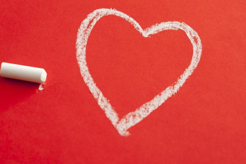Free Stock Photo: Love and romance concept with a heart shape drawn in chalk on a red background with the stick of chalk alongside
