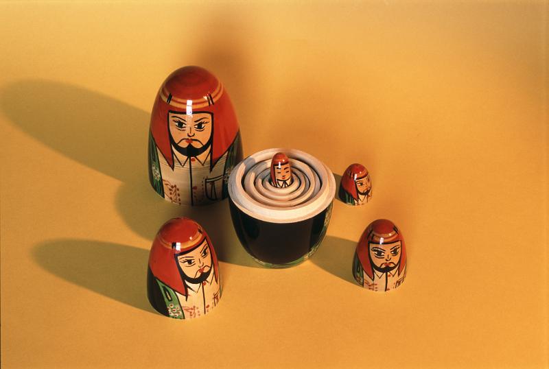 Free Stock Photo: Set of nesting Russian Babushka dolls with the bottom halves stacked and heads surrounding them on yellow