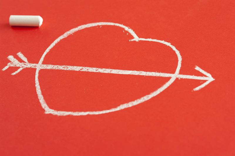 Free Stock Photo: Valentines Day Love background with a chalk sketch of a heart pierced by Cupids arrow on a red background with copy-space