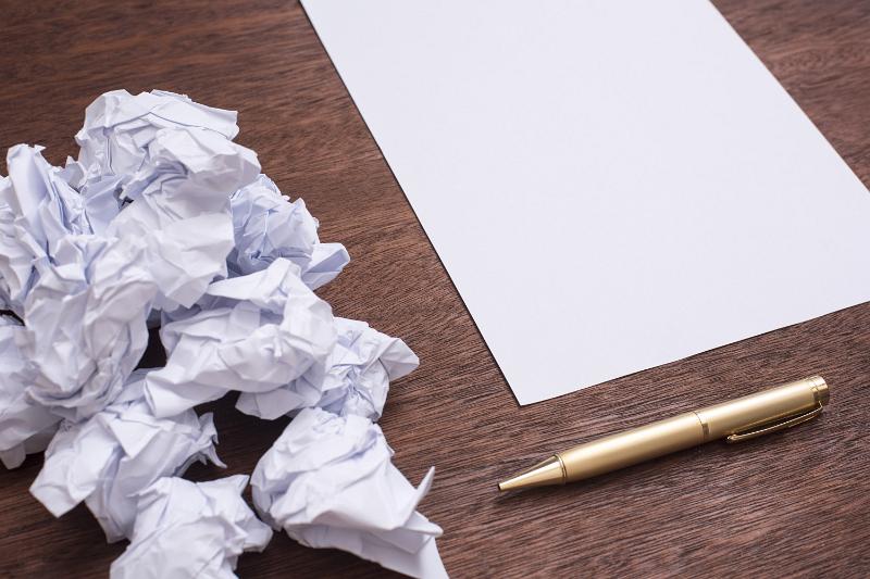 Free Stock Photo: Writers block concept with a bunch of crumpled papers, pen and clean sheet of paper on wooden table