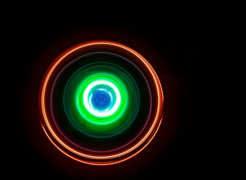 Free Stock Photo: swirls of light in orange and green glowing concentric circles on a black backdrop