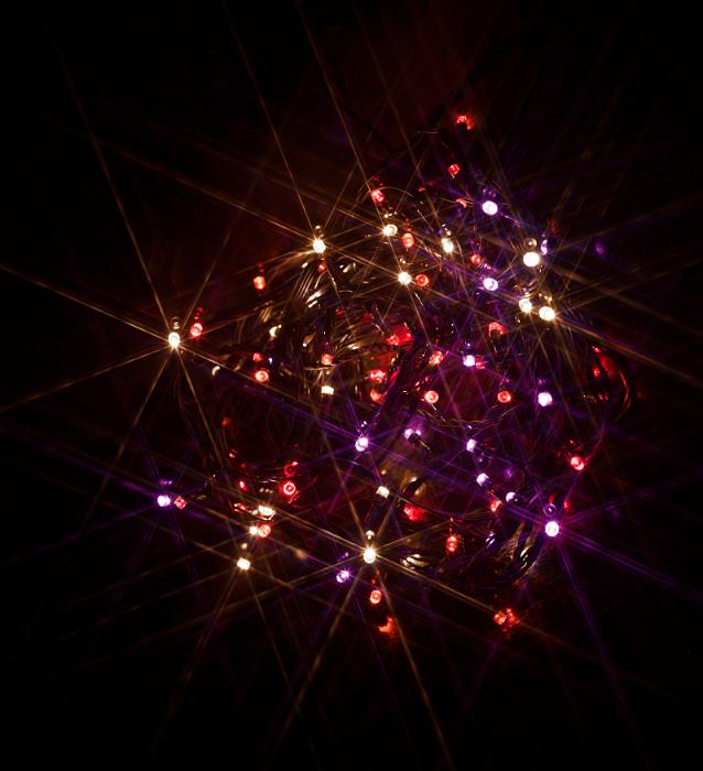 Free Stock Photo: warm coloured pink and purple and amber christmas lights with a starbust filter