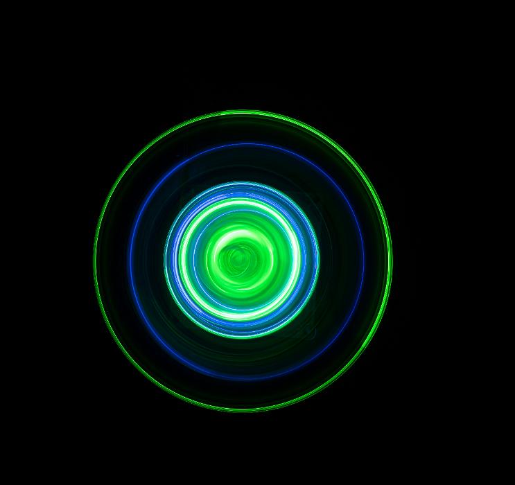 Free Stock Photo: colourful concentric circles of spinning light, green and blue glowing on a black background