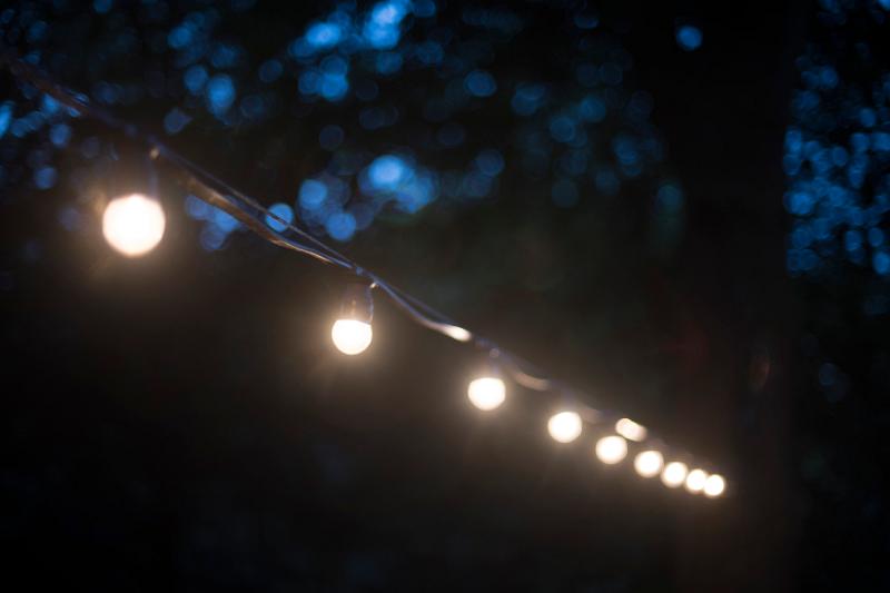 Free Stock Photo: a glowing string of outdoor party lights pictured at dusk