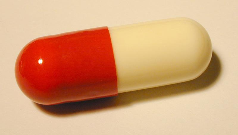 Free Stock Photo: Panoramic Close Up of Red and Off-White Antibiotic Medication Capsule on Plain Background